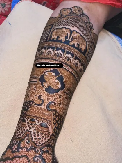This forearm design features traditional motifs like dhol players and elephants, symbolizing the celebration and grandeur of an Indian wedding.
