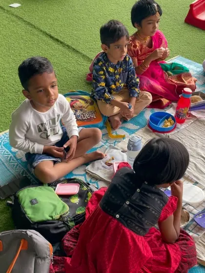 During a break in the festivities, children enjoy their snacks together. These informal moments are just as important for social development as the structured activities.