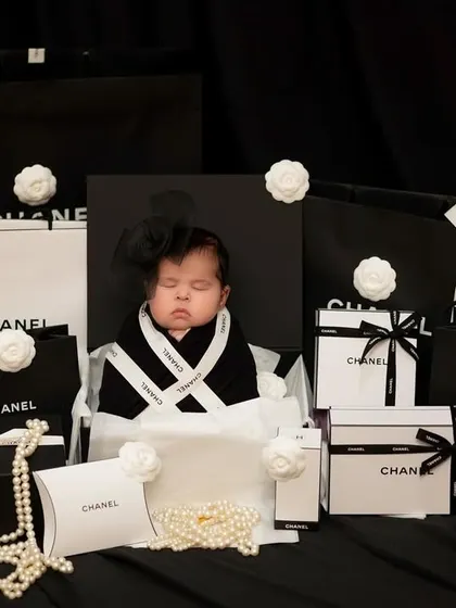 A different angle of our little fashionista, nestled among iconic black and white gift boxes and pearls.