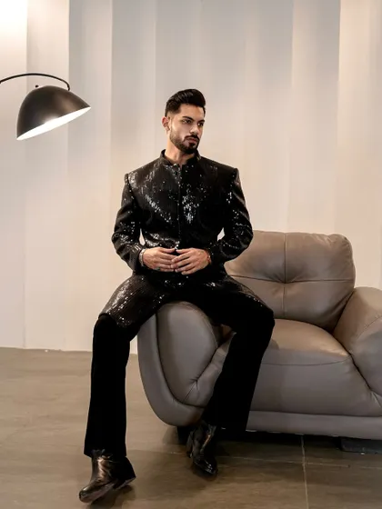 Seated by a modern lamp, the sequins on this jacket create a beautiful play of light and shadow. It's an outfit that feels both contemporary and luxurious.