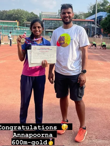 Annapoorna with her coach after winning gold in the 600m race at the Summer Athletic Meet.