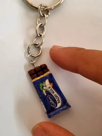 A close-up of the miniature Dairy Milk chocolate keychain. It’s a fun and quirky accessory for anyone with a sweet tooth.