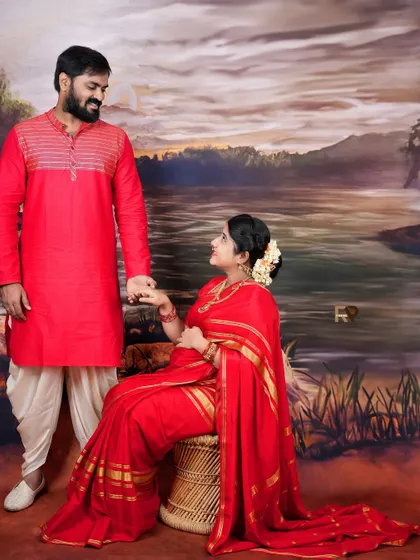 A romantic pose where the couple holds hands, dressed in matching red traditional outfits. Their connection is the centerpiece of this beautiful portrait.