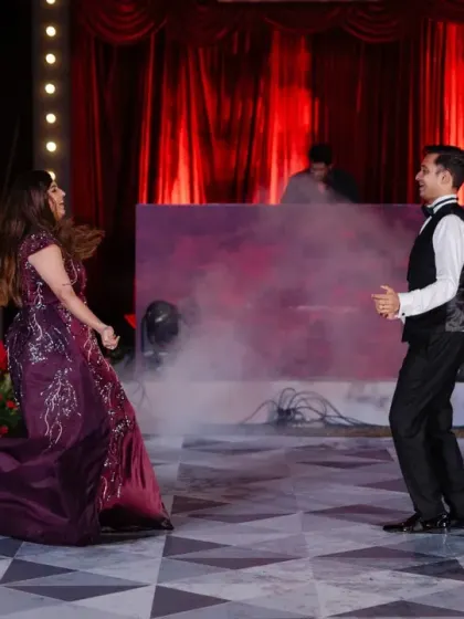 The stage is set for a show-stopping performance. With dramatic lighting and a classic red curtain backdrop, this Broadway-themed Sangeet stage was the perfect setting for the couple's first dance.