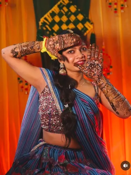 A fun and energetic pose from a happy client at her mehndi ceremony.