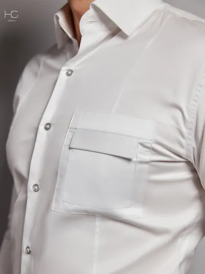 A close-up of the unique flap pocket on the white shirt, a small detail that adds a touch of bespoke design to a timeless piece.
