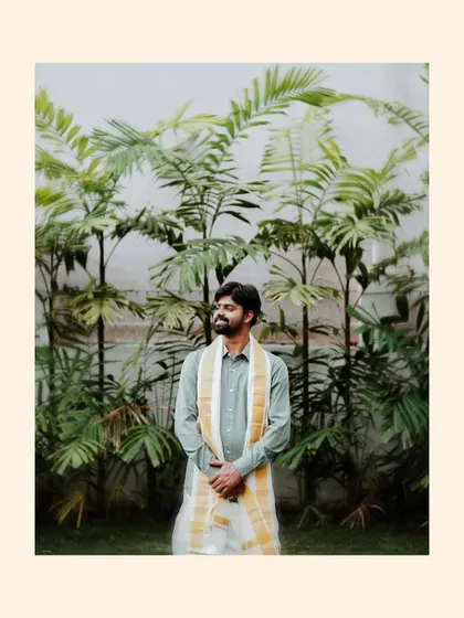 A portrait of the groom in his traditional attire, looking off to the side against a background of palm trees.