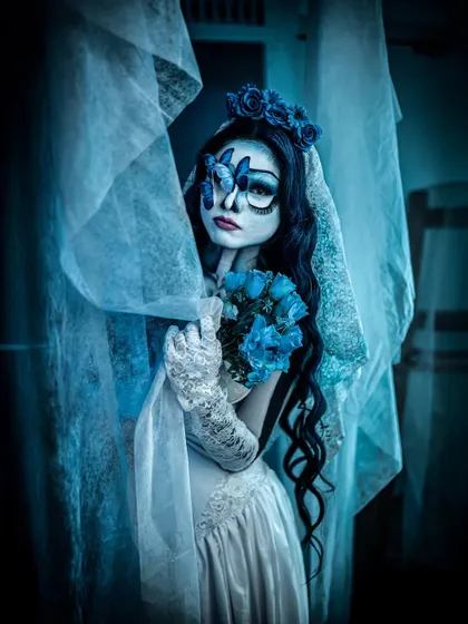 A hauntingly beautiful look inspired by the Corpse Bride. The blue-toned skin, large expressive eyes, and tattered veil perfectly capture the character's melancholic beauty.