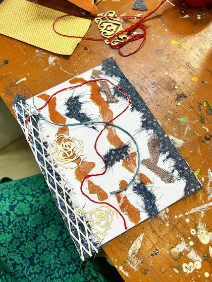 A collagraph plate being prepared. This technique involves creating a collage of different materials on a plate to create unique textures in the print.