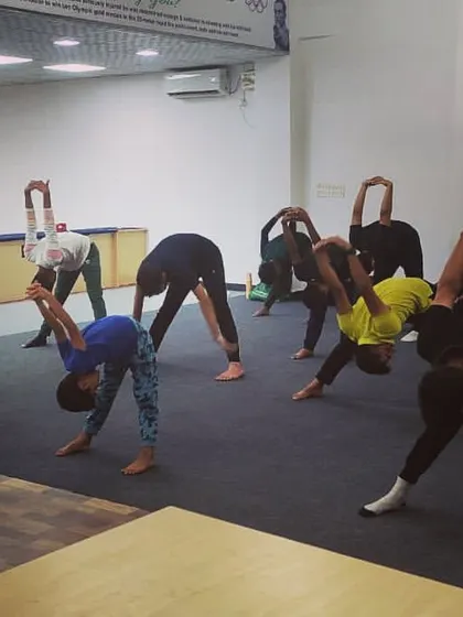 Yoga poses like the forward bend help release tension in the back and shoulders, areas that bear a lot of stress during shooting practice.