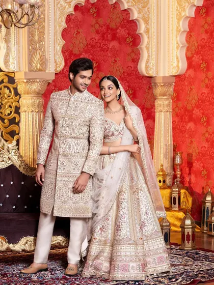 This shot is from an ethnic wear campaign, showcasing a coordinated couple's look for the wedding season. The intricate ivory sherwani and lehenga were styled to create an image of regal elegance and romance.
