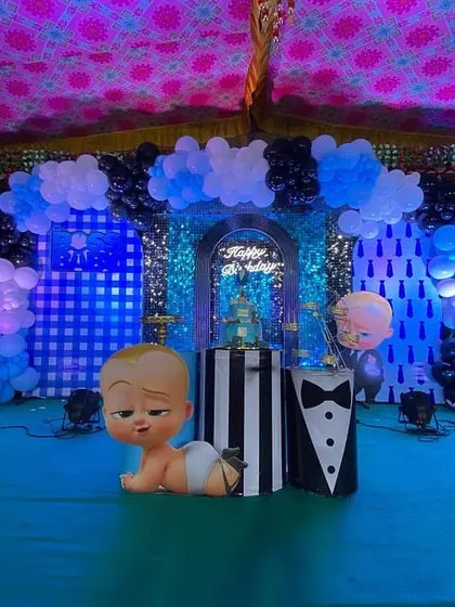 A centered shot of the Boss Baby stage, featuring a crawling Boss Baby prop in the foreground and a cake stand ready for the main event.