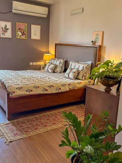 A wider view of my bedroom, showing the wooden bed, the side tables, and the gallery wall. It’s a calm and earthy space.
