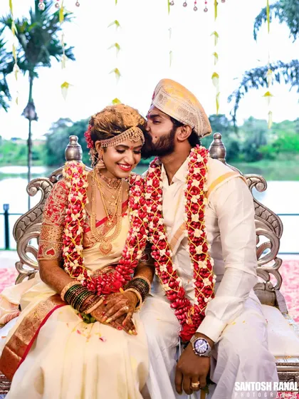 A perfect portrait of the newly married couple, with the groom's kiss conveying love and happiness.