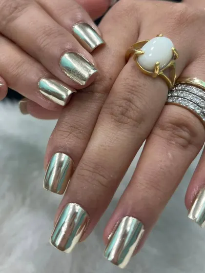 Make a bold statement with these full-coverage liquid gold chrome nails. This reflective, mirror-like finish is applied over perfectly shaped square extensions for a look that is pure luxury and guaranteed to turn heads.