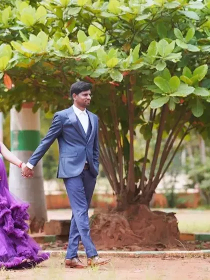 An expecting couple holding hands while taking a stroll through a park. This natural, candid style of photography captures genuine moments of connection.