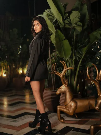 A night-time fashion shoot for Freyja in a beautifully decorated location. The warm ambient lights and lush plants create a magical, enchanting atmosphere.