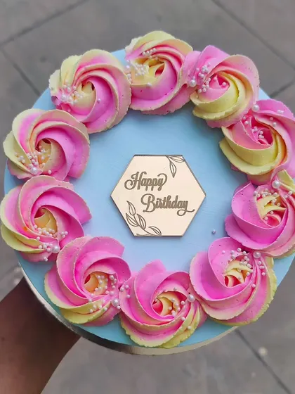 A simple, neat, and crisp design. This pineapple cake is decorated with two-tone buttercream rosettes and a wooden "Happy Birthday" topper.