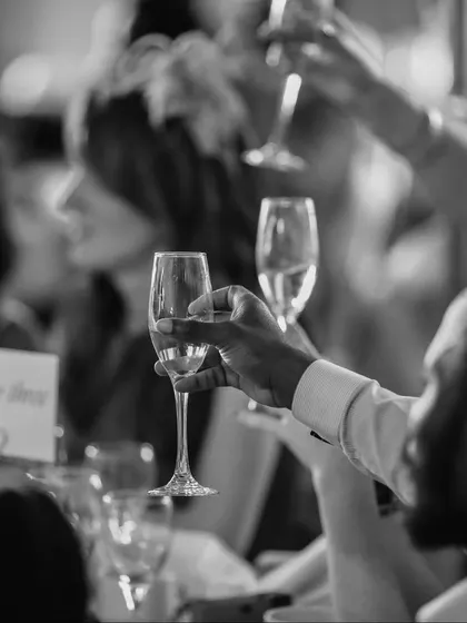 A toast to life's precious milestones. This black and white shot captures the spirit of celebration that is at the heart of everything we do. It is our privilege to create the setting for these moments of joy and connection.