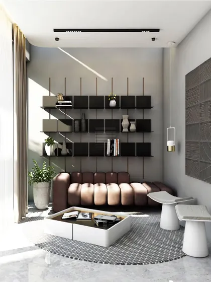 This modern living space is defined by its clean lines and functional elegance. A comfortable brown leather sofa is set against a wall of modular black shelving, creating a perfect nook for reading and relaxation, illuminated by soft, natural light.