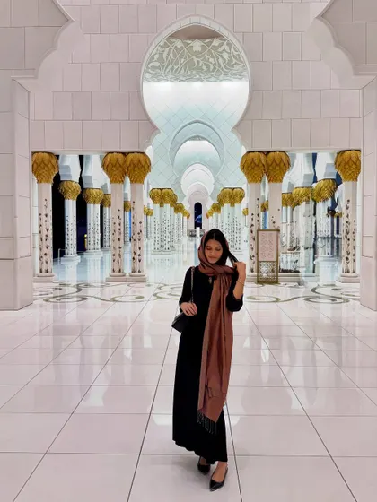 Visiting the Sheikh Zayed Grand Mosque in Abu Dhabi requires a respectful and modest outfit. I wore a simple long black dress and covered my head with a beautiful brown scarf. The look is elegant and appropriate for the serene and exquisite surroundings.