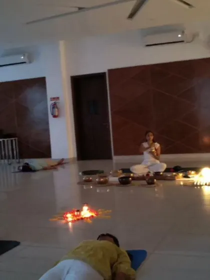 A dimly lit room with participants in Savasana, creating the perfect atmosphere for a deep and healing sound journey.