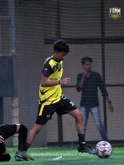 A player focuses on his dribbling technique during a training session. I emphasize keeping the ball close to the feet to maintain control while moving at speed.