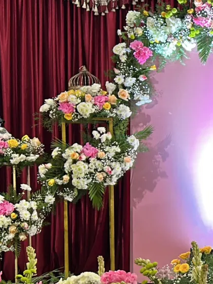 A detailed view of fresh flower arrangements on tall golden stands, used to create a beautiful and sophisticated event atmosphere.