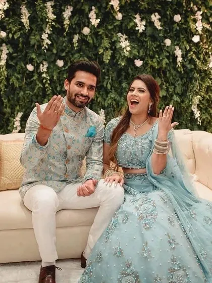 The joy of an engagement ceremony. I created these coordinated light blue outfits, with detailed silver work on her lehenga and a complementary floral jacket for him.
