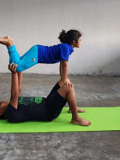 This "flying" pose variation requires balance and control from both the base and the flyer, creating a beautiful, bird-like shape.