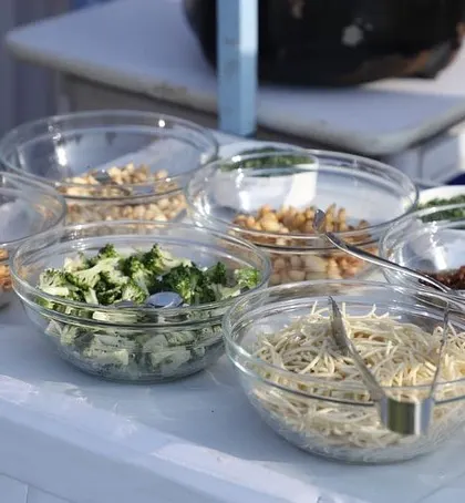 A clear view of the fresh and organized ingredients at one of our live food counters. We believe in transparency and quality, ensuring guests can see the fresh components that go into their meals.