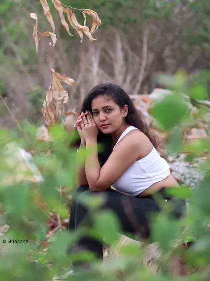 A close-up portrait using natural framing from out-of-focus leaves. This technique adds an artistic touch to outdoor photography.