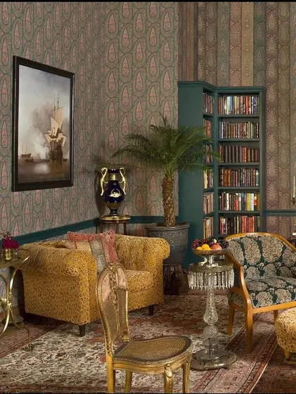 A room from the Sabyasachi collection, showcasing a mix of patterns with a paisley wallpaper and striped accents, creating a layered, maximalist look.