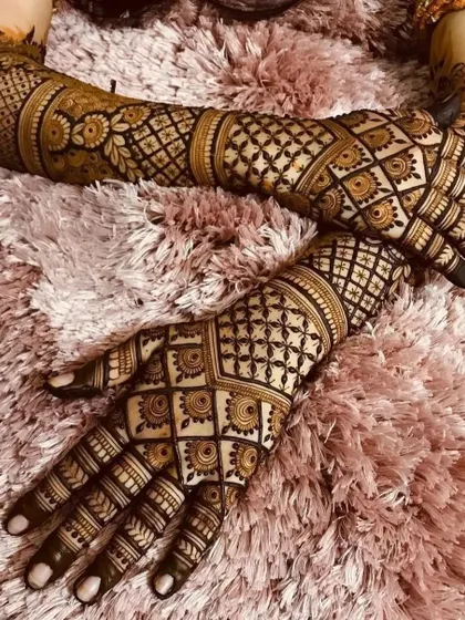 This geometric grid pattern, known as a "jaali" design, covers the hands and arms for a very full and intricate bridal look. It requires a very steady hand to execute perfectly.