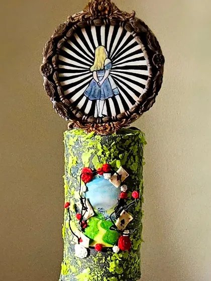 My "Alice in Wonderland" themed cake, which was featured in Cake Masters Magazine. This design uses a tall, narrow tier to create a sense of wonder, with a hand-painted Alice looking into a portal.