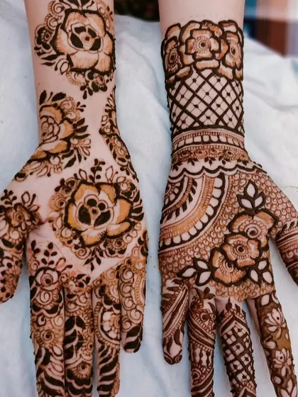 This design showcases large, beautiful rose motifs, a popular element in modern mehendi. The mix of shaded petals and net patterns gives it a three-dimensional feel.