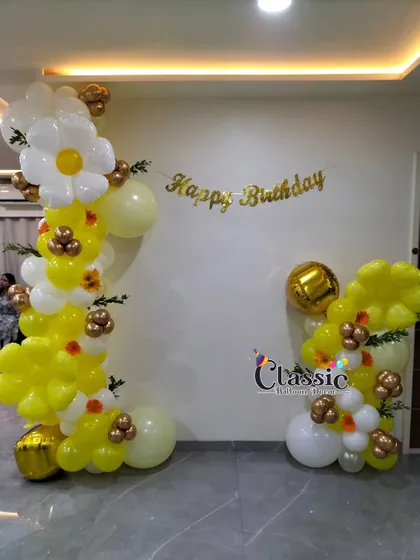 A simple and sweet sunflower theme, with two balloon pillars decorated with daisies, perfect for framing a space at home.
