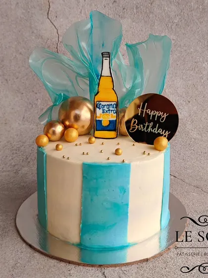 A Corona beer-themed cake for a client who ordered all the way from Canada. This half-kg Chocolate Raspberry cake features blue stripes, rice paper sails, and a printed Corona bottle.