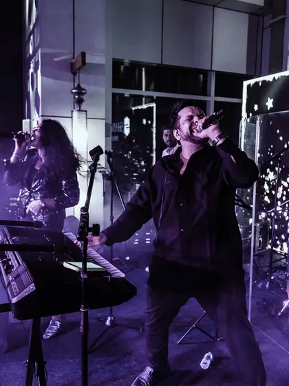 The full band on a rooftop stage, surrounded by atmospheric smoke and lights. We work with event planners to ensure our technical setup enhances the overall production value.