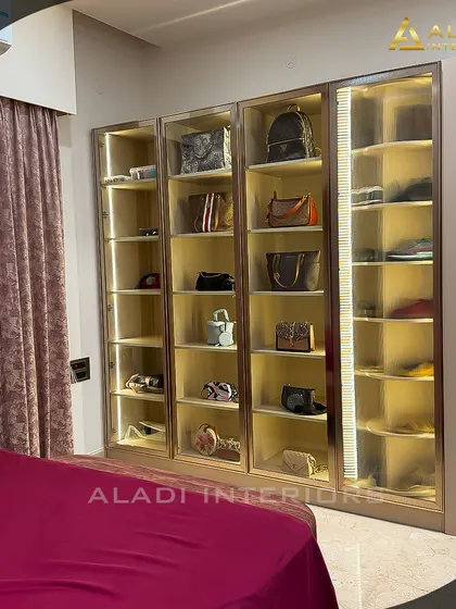 A wider view of the illuminated display cabinet, showing how it is integrated into the bedroom design as a stunning feature piece.