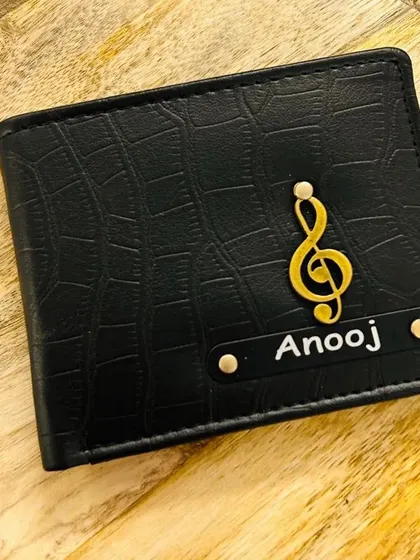 This black croc-textured wallet features a music note charm, making it a great gift for a musician or music enthusiast.