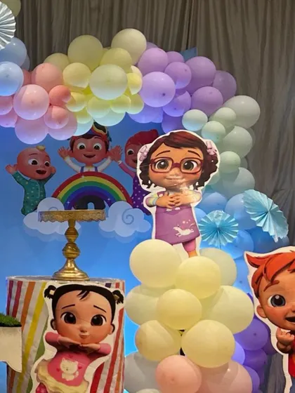 A fun arrangement of Cocomelon character cutouts placed on balloon stands, adding a playful touch to the party space.