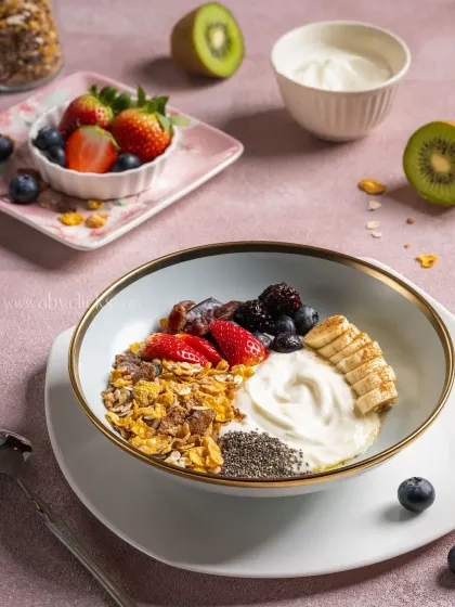A healthy and colorful breakfast bowl with yogurt, granola, and fresh fruits like strawberries, bananas, and blueberries.