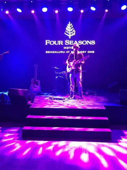 A wide shot of our stage setup at the Four Seasons, showing our full band in a professional concert setting.