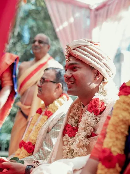 A candid shot of the groom and his family during the wedding ceremony, capturing their happy and engaged expressions.