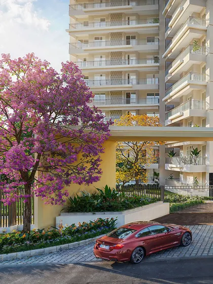 The entrance to a residential community, framed by a beautiful flowering tree. This daytime view creates a welcoming and cheerful first impression.