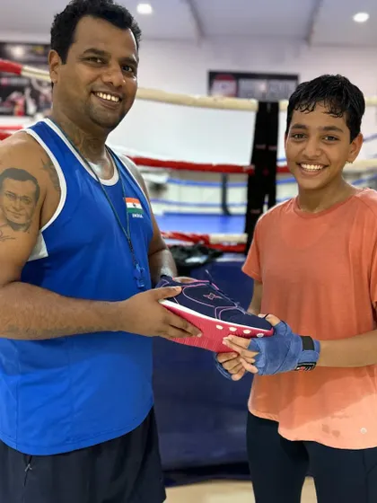 I believe in rewarding hard work. Here I am gifting a new pair of boxing shoes to our national-level boxer, Vedika Satre. When my students succeed, I make sure they know their dedication is appreciated.