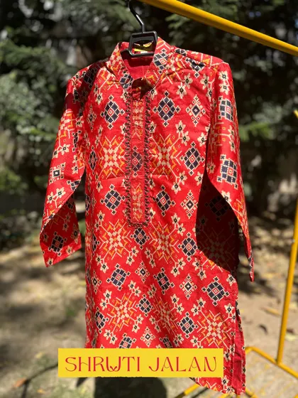 This vibrant red kurta features a traditional ikat-style print. It’s a bold and stylish choice for any little boy who loves to stand out.