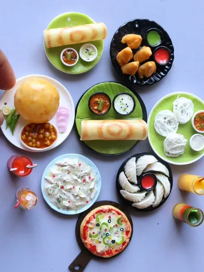 A collection of miniatures including chole bhature, momos, dosa, and pizza, showcasing the wide range of courses I offer.