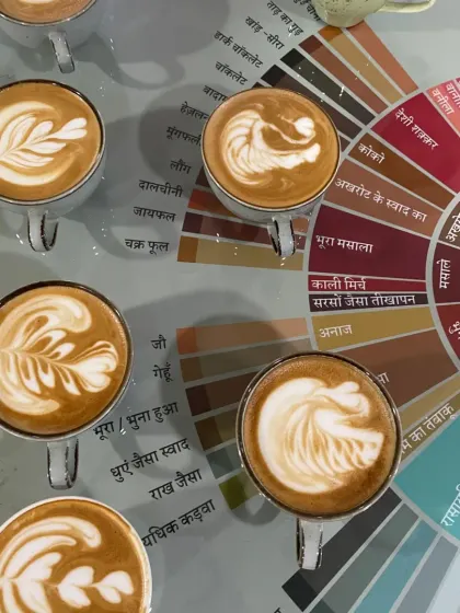 Latte art isn't just about pretty patterns. It's the final touch on a well-crafted drink. Here, you can see our students' work displayed over our Hindi flavor wheel, a tool we developed to make coffee flavors more relatable. We teach both the art and the science behind every cup.